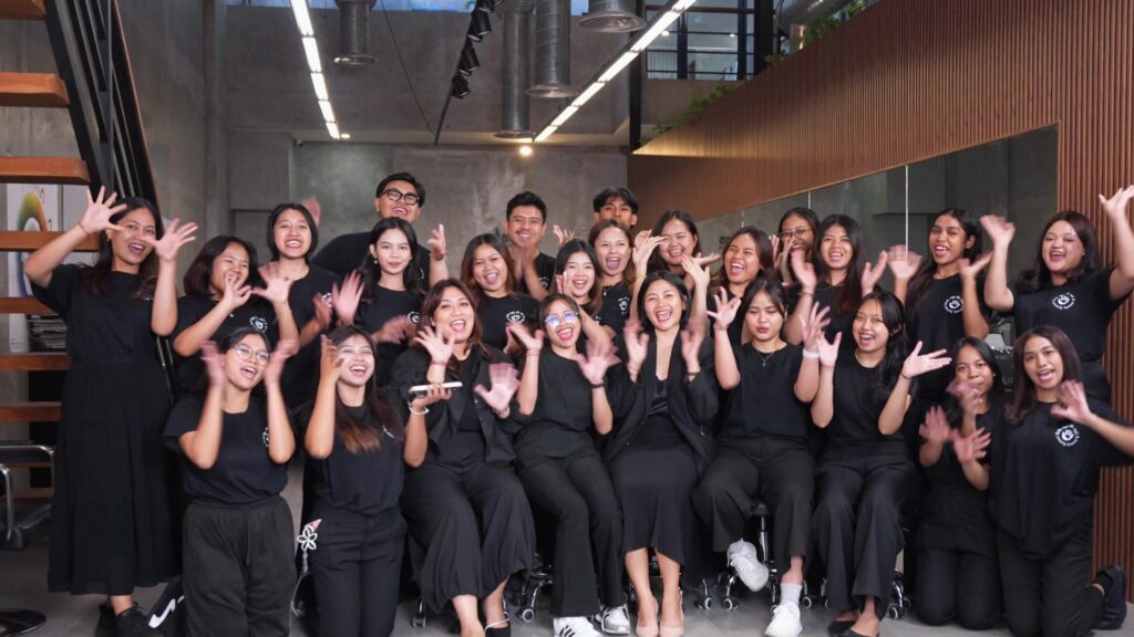 Students of the Skills for Life Hair & Beauty School in Bali cheering for the class photo